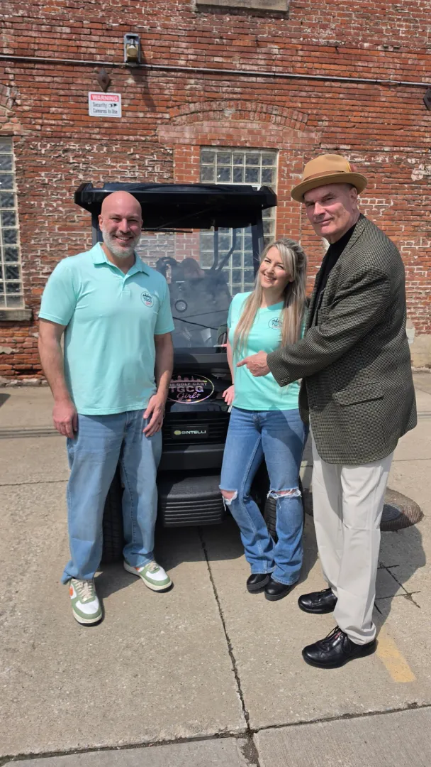 Guests smiling during a premium open-air cart ride in Cleveland.