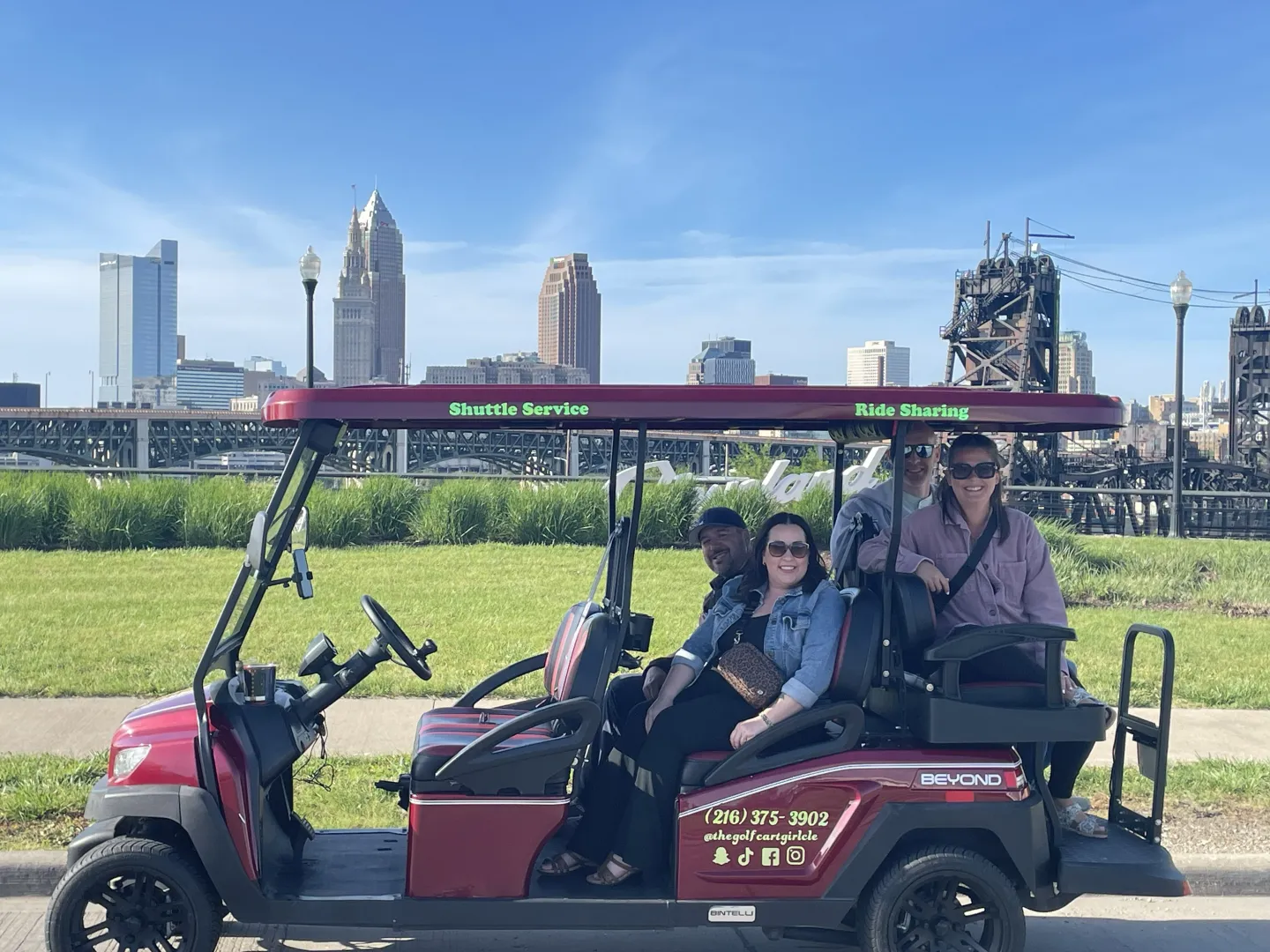 Guests posing at the Tremont Cleveland script sign during a cart ride.
